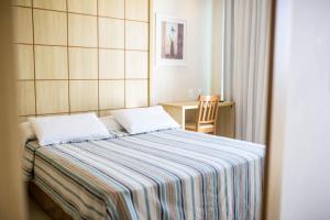 里约热内卢美洲海鸥酒店的一间卧室配有带条纹毯子的床