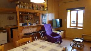 VertambozLa fontaine的厨房设有酒吧、紫色椅子和桌子
