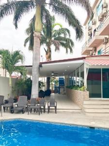 曼塔Hotel Mar Azul的一个带游泳池和棕榈树的度假村