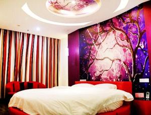高淳区尚客优连锁江苏南京高淳大市场店的卧室配有一张床,墙上挂有绘画作品