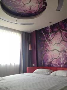 武汉尚客优连锁湖北武汉东西湖区径河街店的一间卧室配有一张床和紫色的墙壁