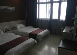 苏州尚客优连锁江苏苏州吴江步行街店的酒店客房带两张床和两个窗户