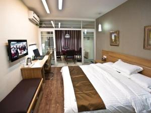 扬州尚客优连锁江苏扬州邵伯大运河店的酒店客房设有一张大床和一张书桌。