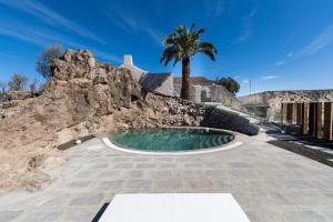 TafiraVilla Hacienda de la Guirra的棕榈树岩石壁上的游泳池
