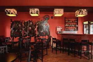 布加勒斯特仙境旅馆的餐厅设有酒吧、椅子和红色的墙壁