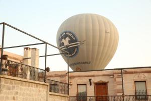 乌奇希萨尔赫尔墨斯窑洞酒店的坐在大楼顶上的热气球