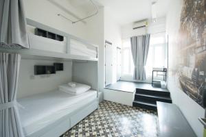 曼谷卡查北德旅舍的一间卧室设有两张双层床和一扇窗户。