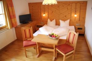 费斯Hotel Garni Apart Elfriede的一间卧室配有一张床和一张桌子及一碗水果