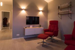 霍尔斯沃德吕尔Bryggjur的客厅配有2把红色椅子和电视