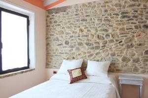 San Giorgio PiacentinoAgriturismo Ca' Preda的一间卧室设有石墙和白色的床