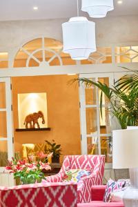 塞维利亚科拉尔精品酒店 - 德尔雷伊的大堂设有粉红色的沙发和一幅熊的画作