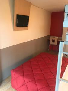 索肖普瑞米尔蒙贝利雅得索尚经典酒店的卧室配有红色的床,墙上配有电视