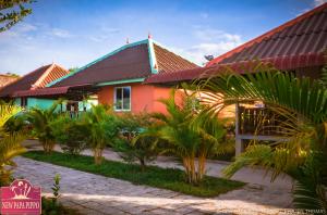 西哈努克新爸爸皮波度假酒店的一座红色屋顶的房子,还有一些棕榈树