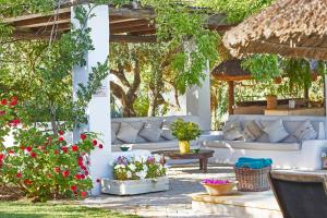 拉斯卡韦萨斯-德圣胡安圣拉菲尔庄园酒店的庭院设有白色的沙发、鲜花和树木