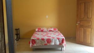 JoanesPousada das Estrelas的一间卧室配有一张带红白毯子的床