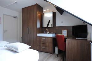 梅赫伦Hotel De Oude Brouwerij的一间卧室配有床、水槽和镜子