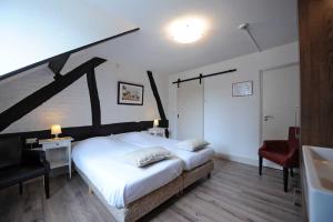 梅赫伦Hotel De Oude Brouwerij的一间卧室配有一张大床和一张红色椅子