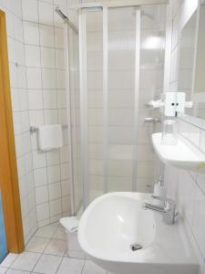 托尔高托尔高中心酒店的白色的浴室设有水槽和淋浴。