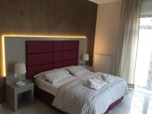 莱切S'Oronzo Modern Town House的一间卧室配有一张大床和红色床头板