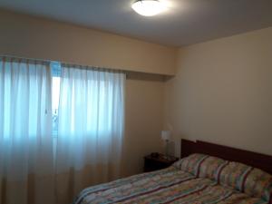 罗萨里奥Como en Casa 2的一间卧室配有床和带窗帘的窗户