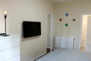 毕尔巴鄂Apartamento Villarias的卧室配有壁挂式平面电视