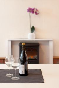 布里斯托麦西提哈温 - 其品 - 城市中的乡村生活度假屋的桌子上放有一瓶葡萄酒和两杯酒