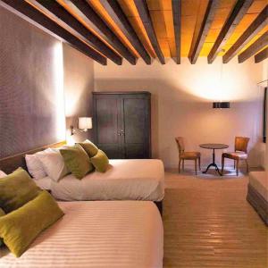 莱昂Othelo Boutique Hotel Mexico的酒店客房设有两张床和一张桌子。