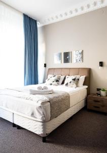 斯德哥尔摩霍特哥特酒店的卧室配有一张带蓝色窗帘的大型白色床