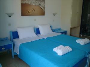 巴利恩依克诺玛奇思公寓的一张蓝色的床,上面有两条白色的毛巾