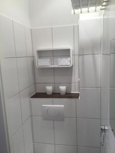 布伦瑞克feelgood Apartments - Apartment Chic的白色瓷砖浴室,架子上放着两杯