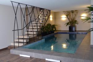 普埃布拉Hotel 5 de Mayo的一座带楼梯的房屋内的游泳池