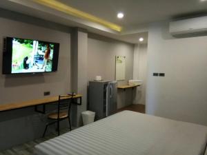 梭桃邑索尔克尔索尔度假村的一间卧室配有一张床和一张书桌,墙上配有电视。