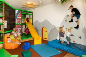 弗拉绍迪洛勒霍夫酒店的一间有孩子在带攀岩墙的游戏室玩耍的房间