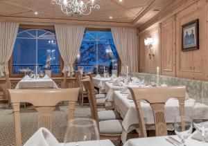 奥伯古格尔阿尔盆兰德酒店的餐厅配有白色的桌椅和吊灯
