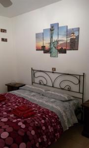 阿斯蒂Cristina's Flat的卧室内的一张床铺,墙上挂有绘画作品