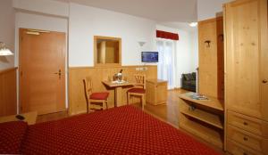 莫尔韦诺Hotel Zurigo的客房设有一张床和一张桌子及椅子