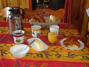 圣皮埃尔多德曼住宿加早餐膳食公寓酒店的餐桌,带桌布,面包和橙汁