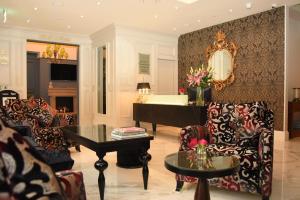 基拉尼锦绣精品酒店的客厅配有钢琴、椅子和桌子