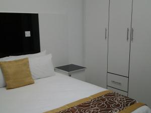 哈博罗内Keeme-Nao Self Catering Apartments的一间带床和橱柜的小卧室