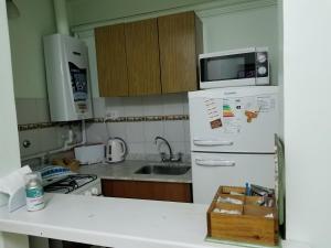布兰卡港M&A Apartamentos Temporales的厨房配有白色冰箱和微波炉