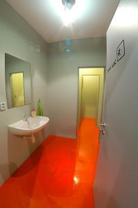 特罗亚诺维采Penzion UAX的浴室铺有橙色地板,配有盥洗池。