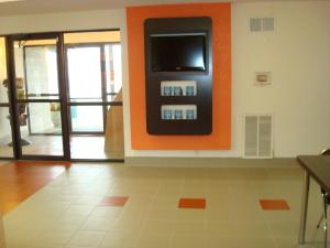 阿卡德尔菲亚Motel 6-Arkadelphia, AR的一间拥有橙色墙壁的客房,墙上配有电视