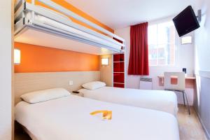 尚布雷莱图尔南图尔 - 图尔钱布雷布普瑞米尔经典酒店的一间酒店客房,设有两张床和电视