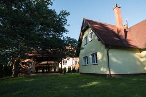 OgonkiLetniskowa 30 - Całoroczny dom do wynajęcia的院子里的绿色房子,有红色屋顶