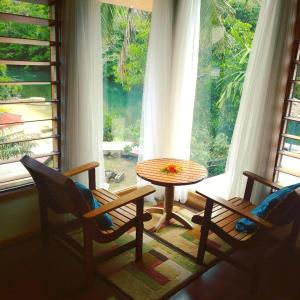 萨武萨武盐湖山林小屋的客房设有桌椅和窗户。