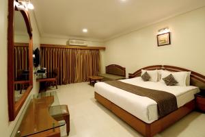 奥兰加巴德Hotel AGC的配有一张床和一张书桌的酒店客房