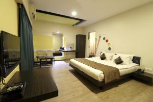 奥兰加巴德Hotel AGC的一间卧室设有一张床和一间客厅。