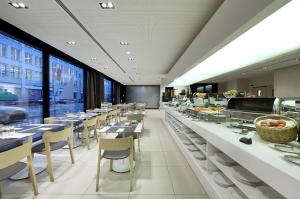 慕尼黑欧洲之星预订酒店的一间带桌椅的用餐室和一间自助餐厅