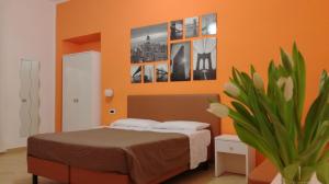那不勒斯玻薇欧套房酒店的卧室配有一张床,墙上挂有图片