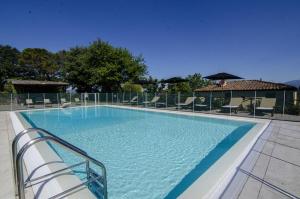 蒙特瓦尔基Il Castellare的一座蓝色海水和椅子的大型游泳池